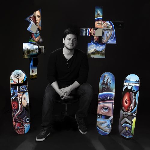 Steve sits with his canvas pieces on the wall above his new skateboard art..